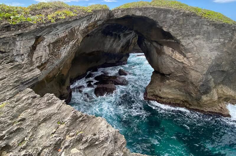 Waves crashing through a limestone sea arch